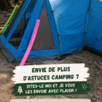 Une tente de camping installée dans la nature avec des équipements de camping bien organisés.